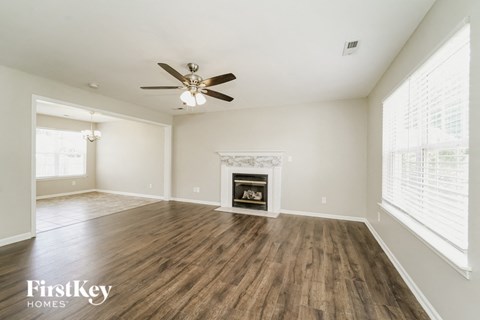 A spacious living room with a fireplace and wood flooring.