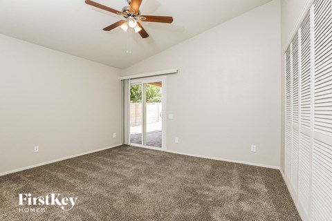a living room with carpet and a ceiling fan