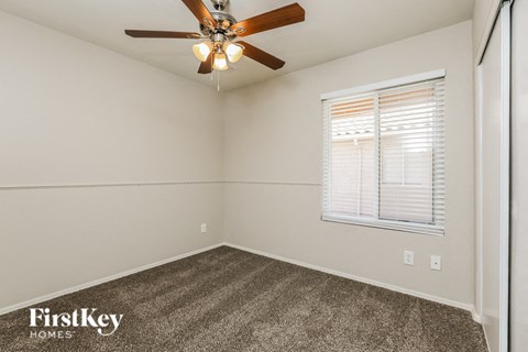 a bedroom with a ceiling fan and a window