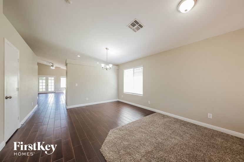 a spacious living room with hardwood flooring and white walls