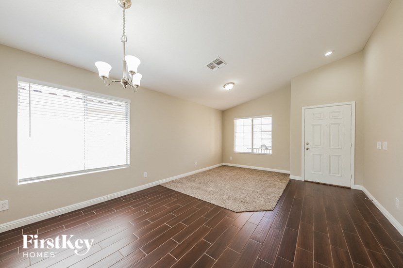 the spacious living room with hardwood flooring and a white door