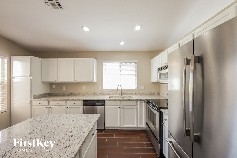 a kitchen with white cabinets and stainless steel appliances