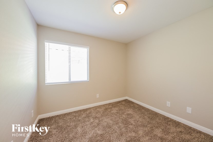 an empty room with carpet and a window
