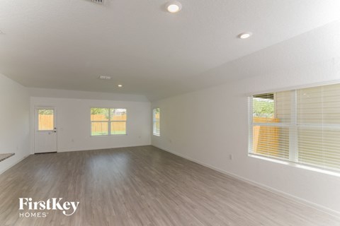the living room of an empty house with wood floors and white walls