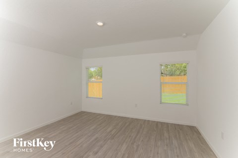 the living room of a house with wood floors and white walls