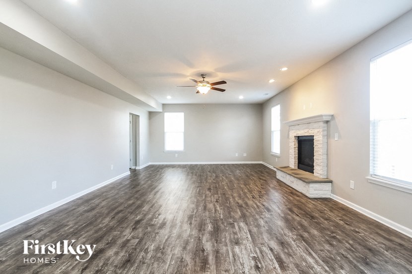 A spacious room with wooden floors and a fireplace.
