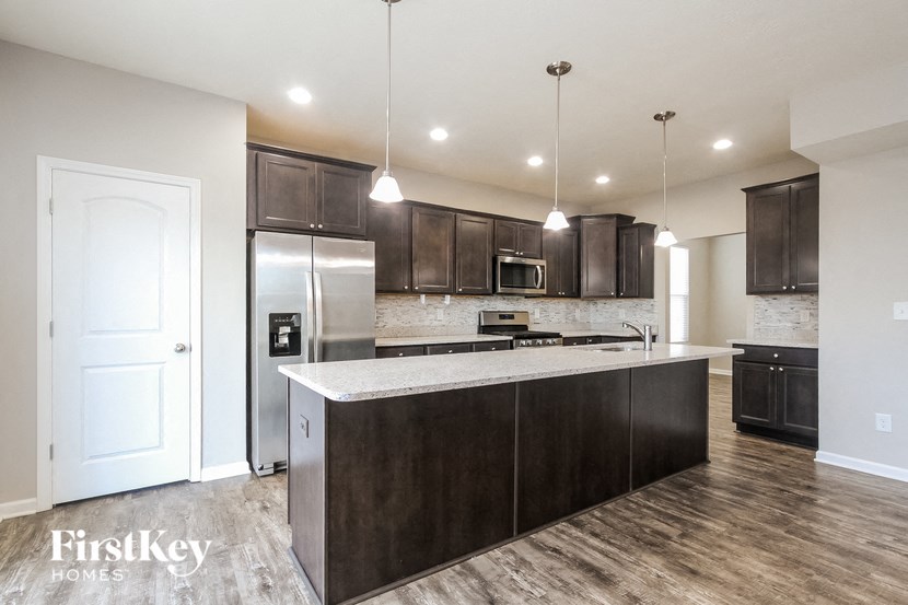 A modern kitchen with dark wood cabinets and a white island.