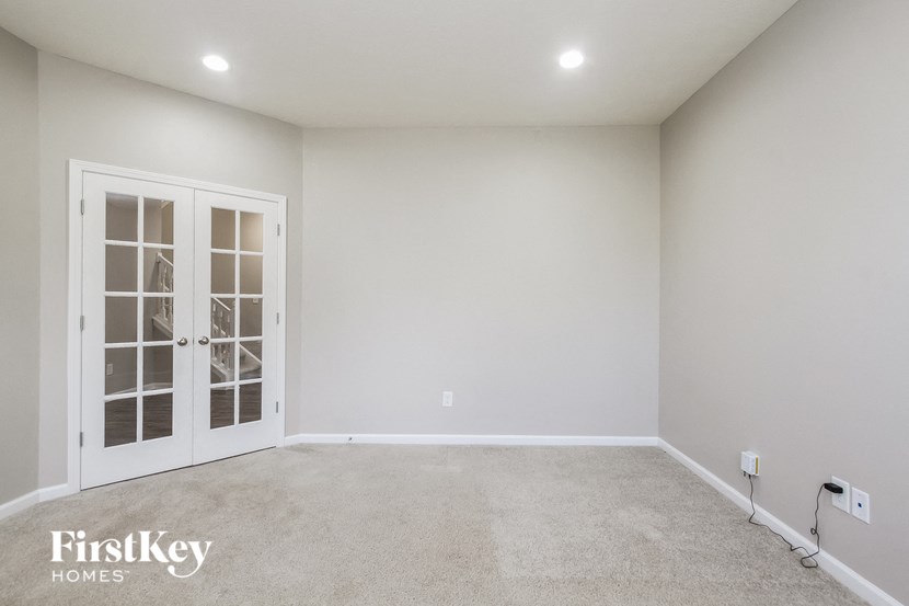 A room with a white door and carpeted floor.