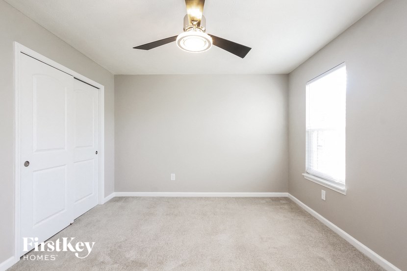 A room with a ceiling fan and a door.