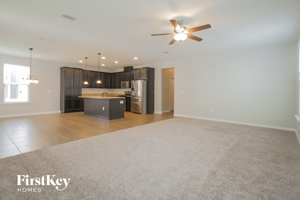 an open living room and kitchen with a ceiling fan