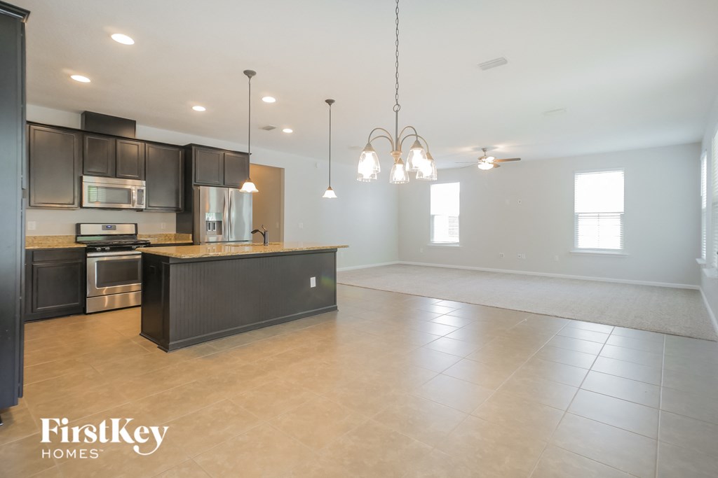 an empty kitchen and living room with a large empty space