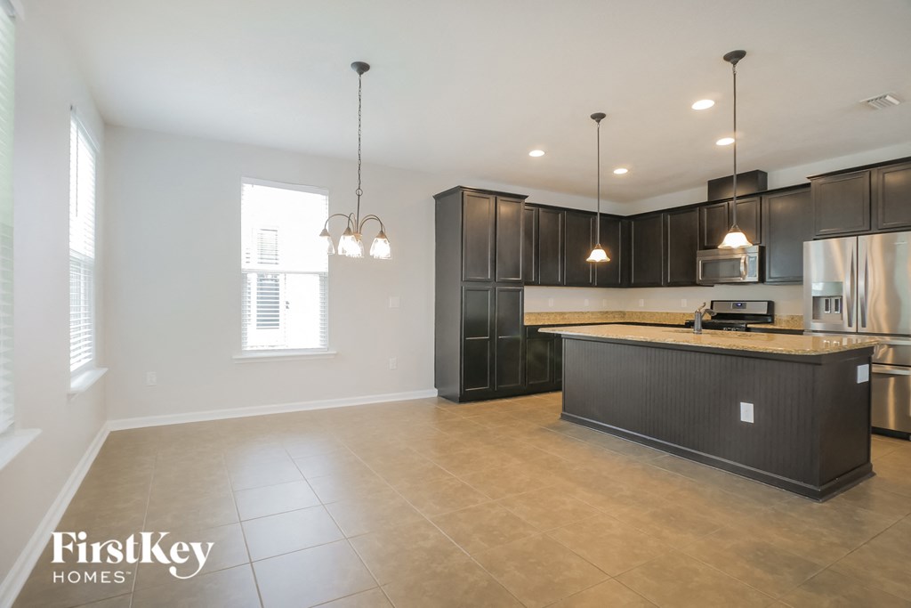 a large kitchen with dark wood cabinets and a large counter top