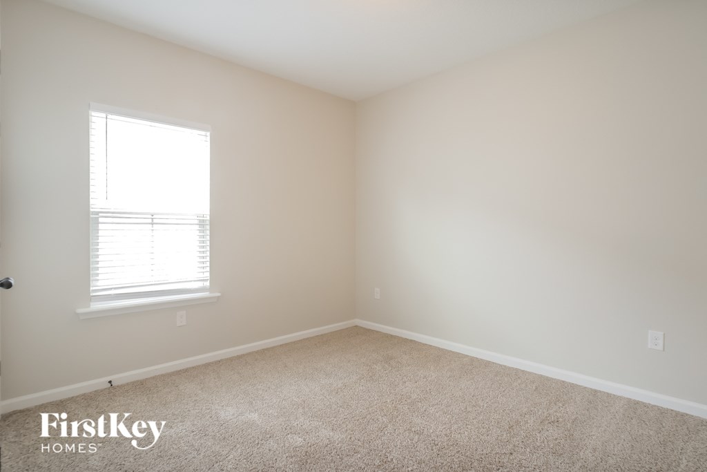an empty room with a window and carpet