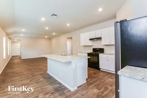 A kitchen with a refrigerator on the right and a countertop in the middle.