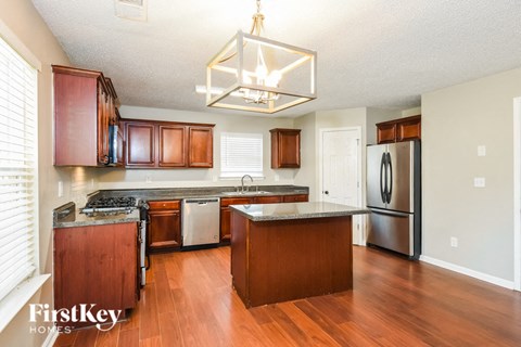 a kitchen with wooden cabinets and stainless steel appliances and a chandelier