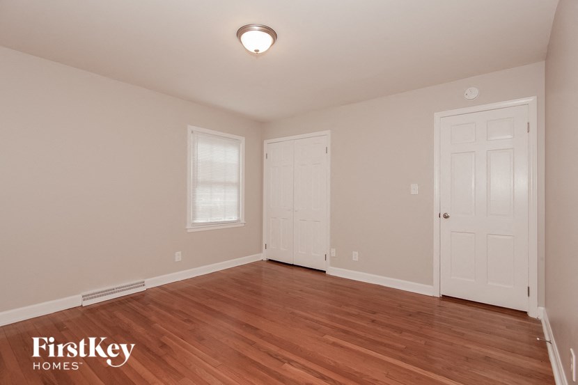 the spacious living room with hardwood flooring and two doors