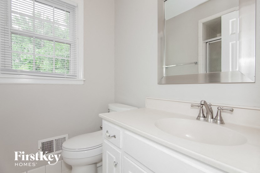 a white bathroom with a mirror and a toilet and a sink