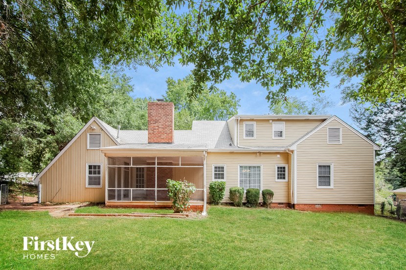 a white house with a large yard and a screened porch
