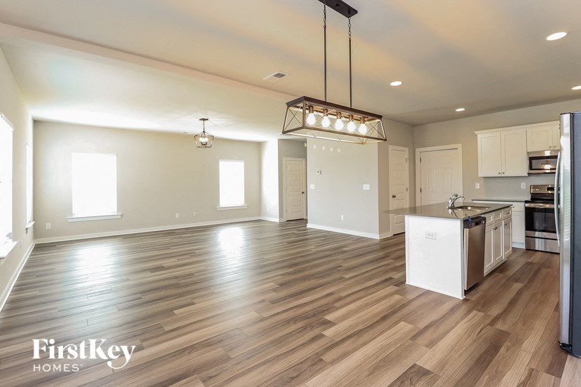 an empty kitchen and living room with wood flooring