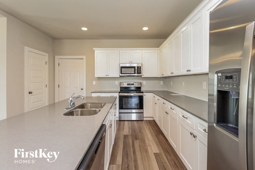 a kitchen with white cabinets and stainless steel appliances