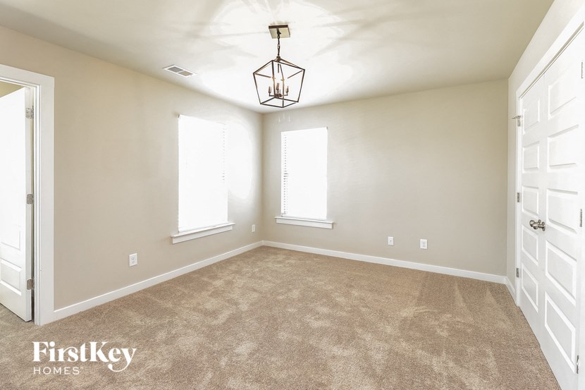 a bedroom with a carpeted floor and a chandelier