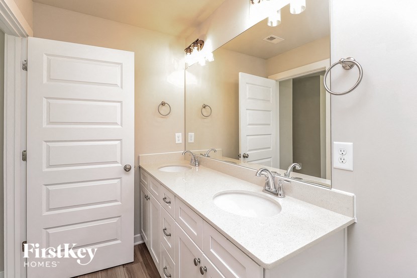 a white bathroom with a sink and a mirror
