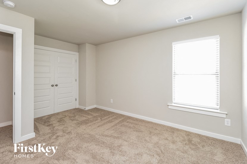 a bedroom with a closet and a door and a window