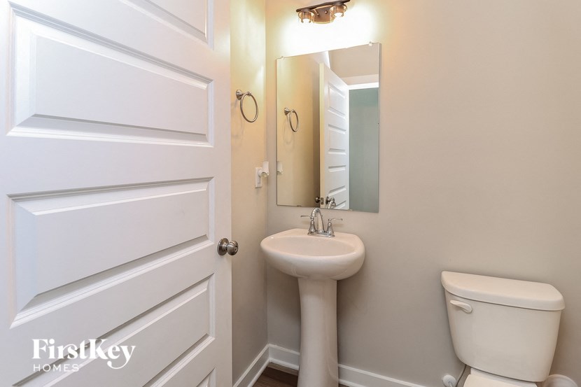 a bathroom with a sink toilet and a mirror
