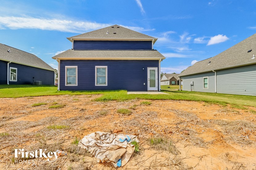the front yard of a blue house with a pile of trash in the yard