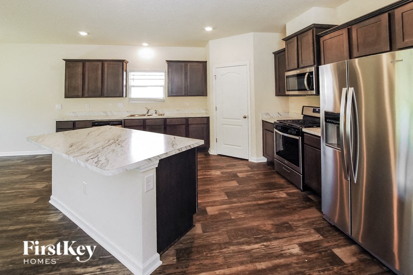 A kitchen with a stainless steel refrigerator, oven, and microwave.