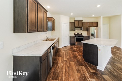 A kitchen with wooden floors and a white counter top.