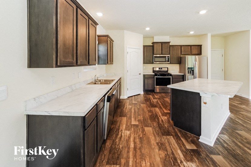 A kitchen with wooden floors and a white counter top.