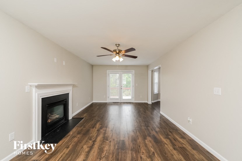 a living room with a fireplace and a ceiling fan