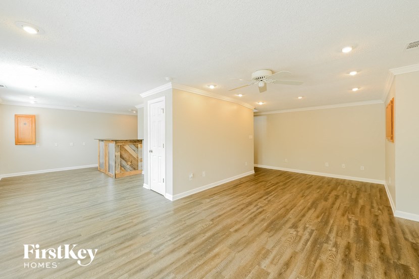an empty living room with a wood floor and a ceiling fan
