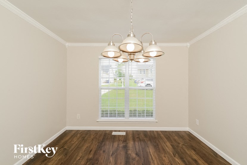 an empty room with a window and a chandelier