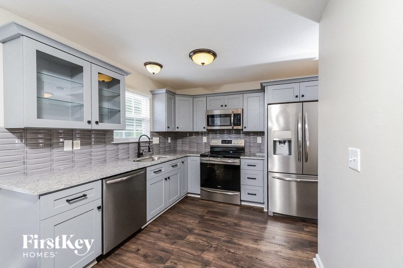 a kitchen with white cabinets and stainless steel appliances