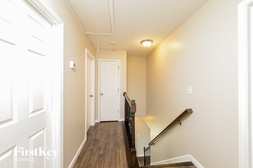 the landing of a staircase in a home with a white door