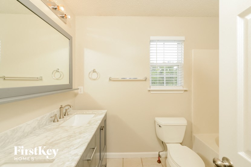 a bathroom with a toilet and a sink and a mirror