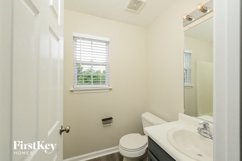 a bathroom with a sink toilet and a mirror