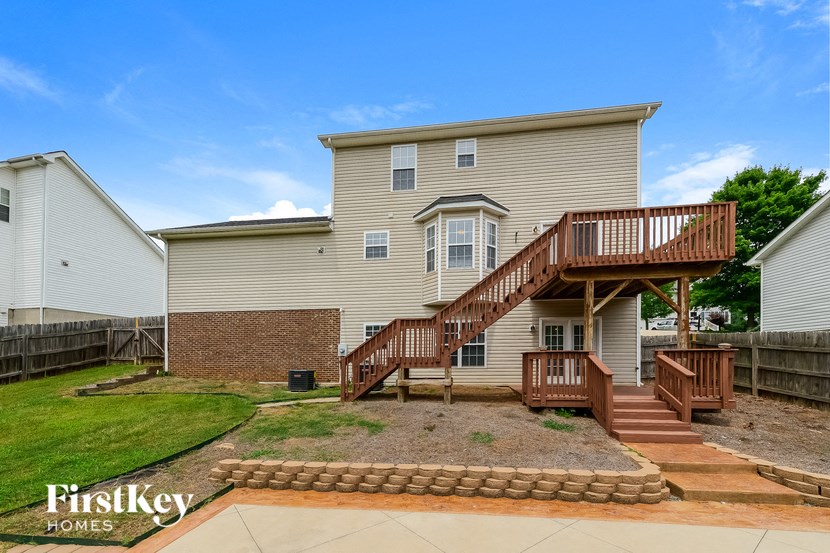 the back of a house with a wooden deck and stairs