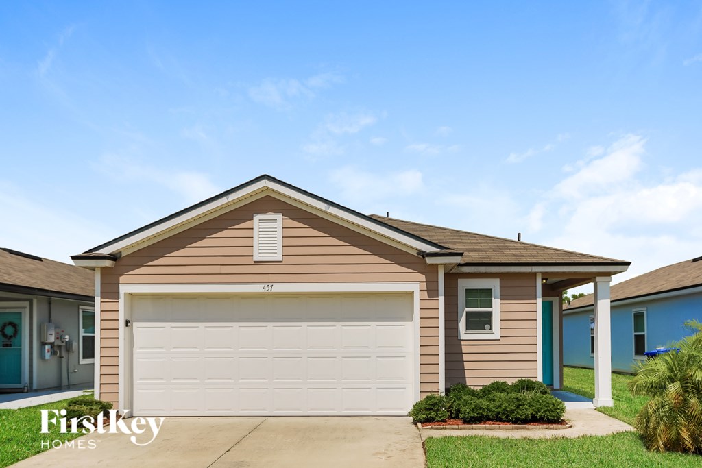 A house with a garage door and a sign that says Firstkey Homes.