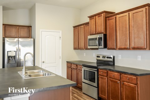 A kitchen with brown cabinets and a stainless steel refrigerator.