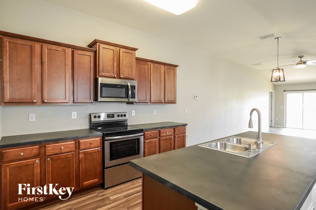 A kitchen with wooden cabinets and a stainless steel sink.