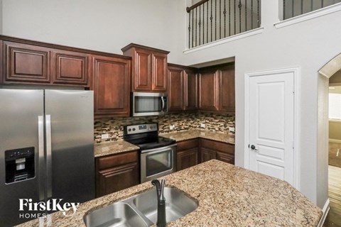 the kitchen has granite counter tops and stainless steel appliances