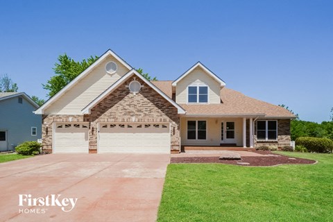 A house with a garage and a driveway in front of it.