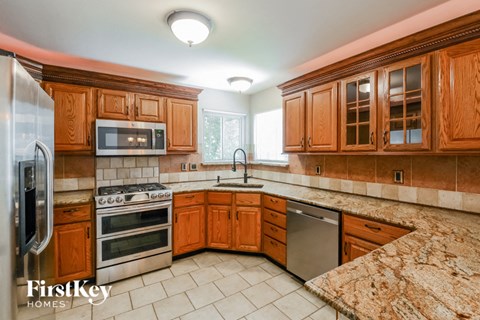 A kitchen with wooden cabinets and granite countertops.