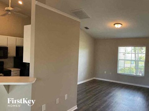 an empty room with a kitchen and a window
