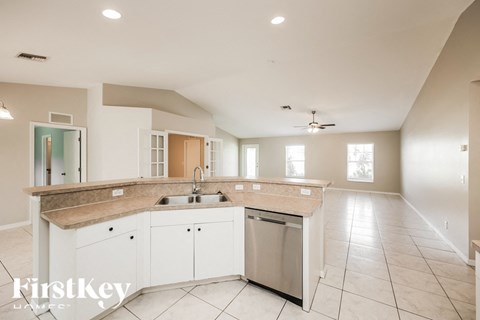 a large kitchen with white cabinets and a stainless steel sink