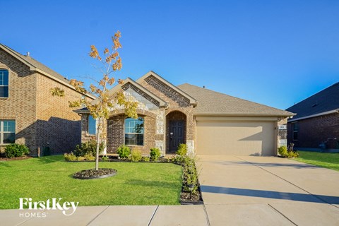 a brick house with a tree in front of it