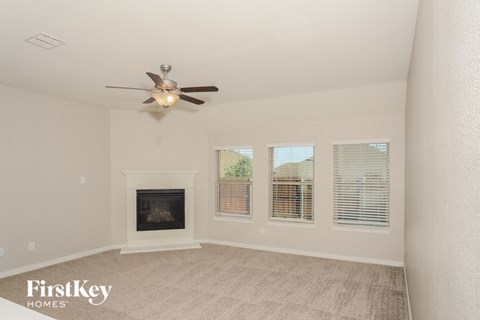 a living room with a ceiling fan and a fireplace